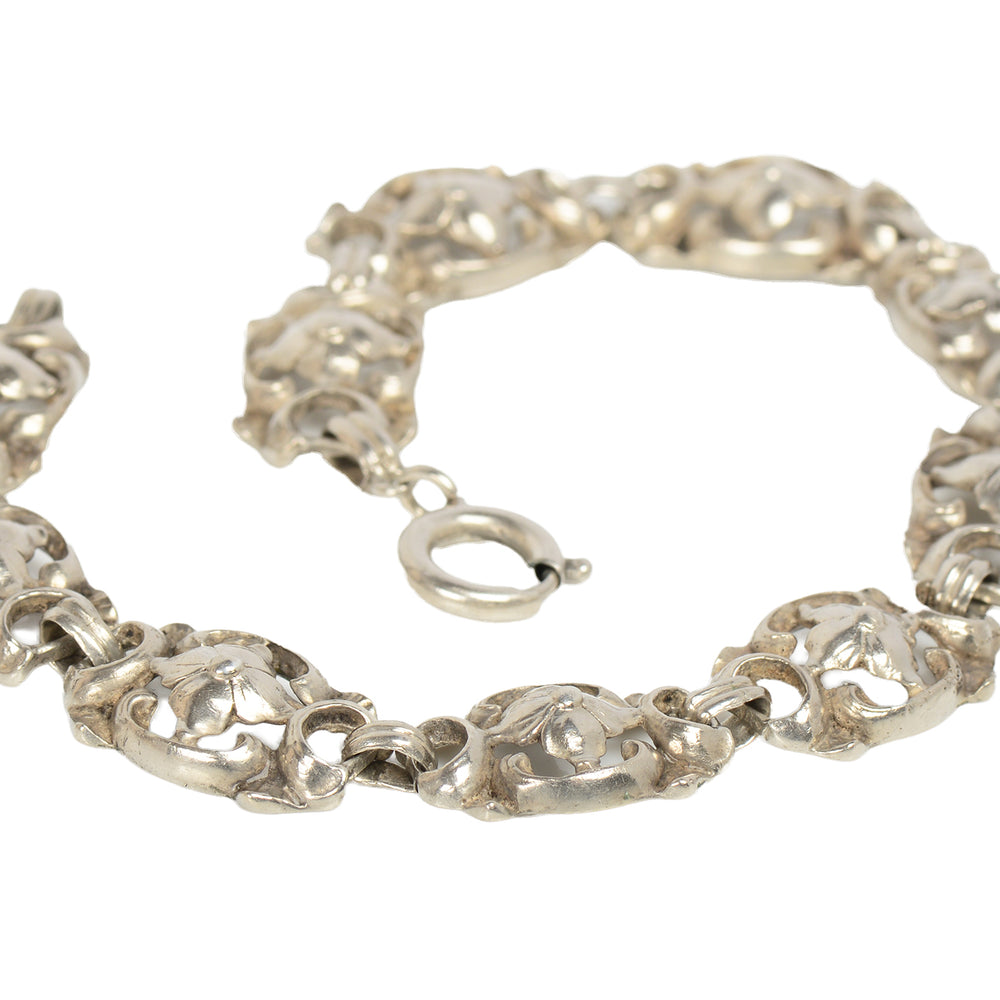 Silver bracelet with floral designs on a white background