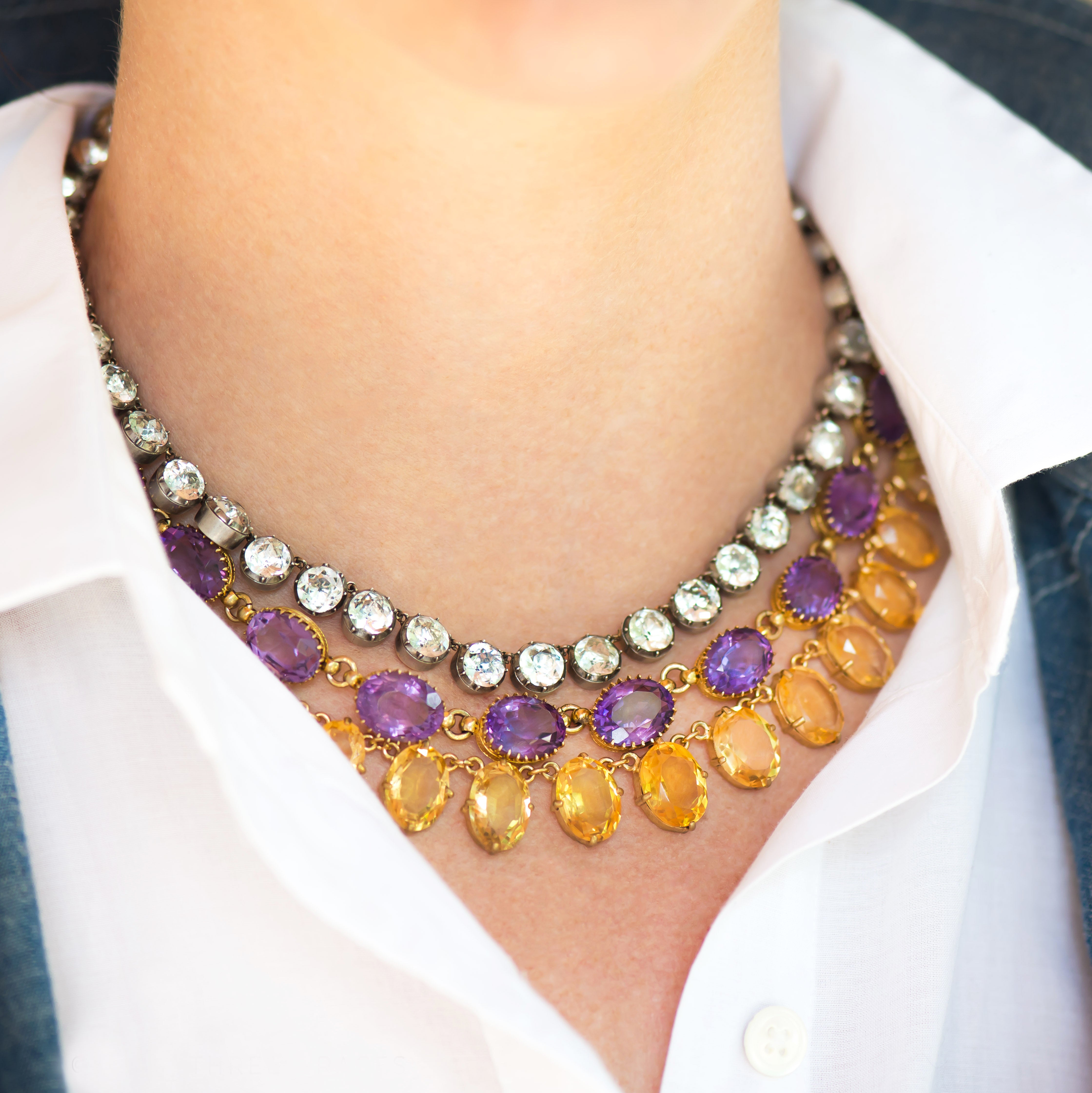 Layered gemstone necklaces on neck